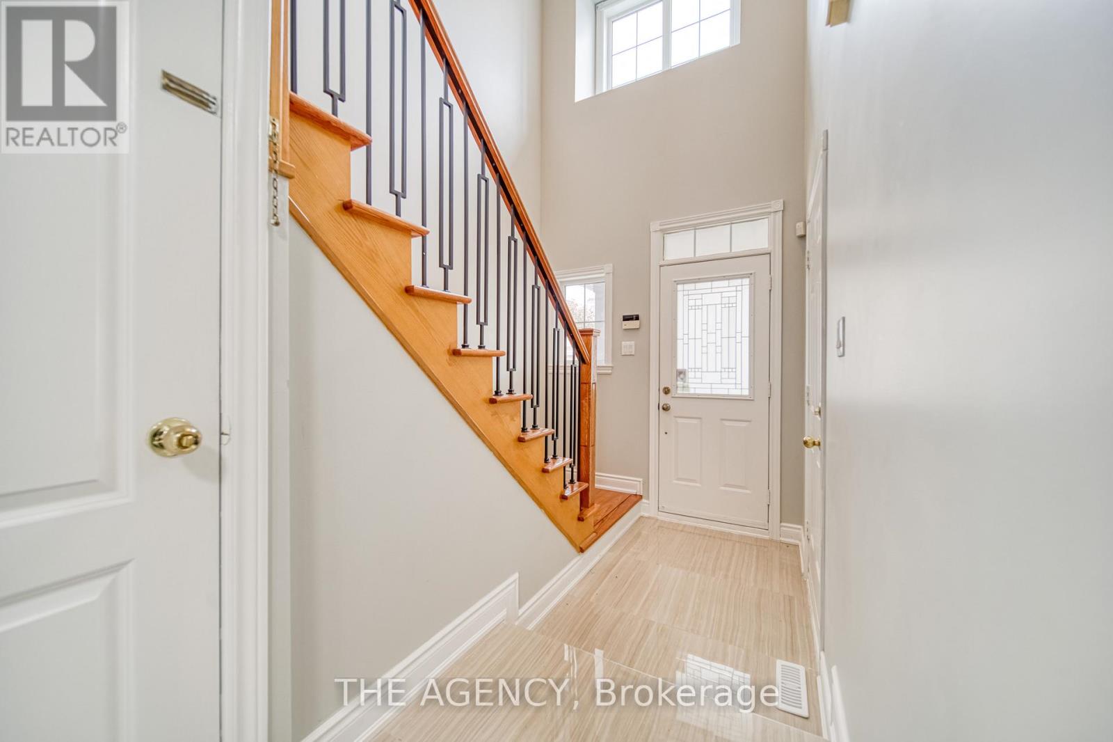 A hallway with a staircase and a door.