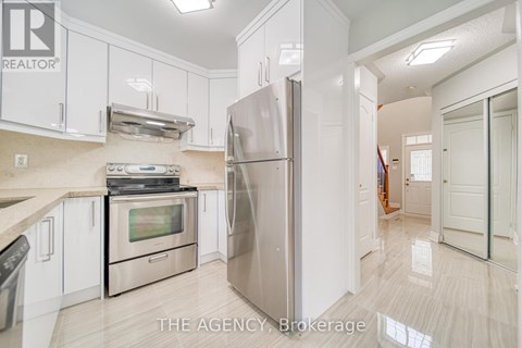A kitchen with white cabinets and a stainless steel refrigerator.
