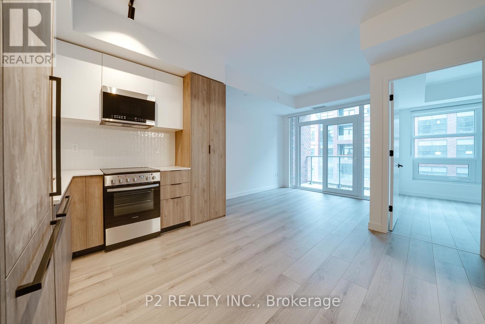 A modern kitchen with wooden cabinets and a stainless steel oven.