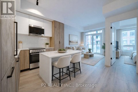 A modern kitchen with a dining area and a living room with a couch and a coffee table.
