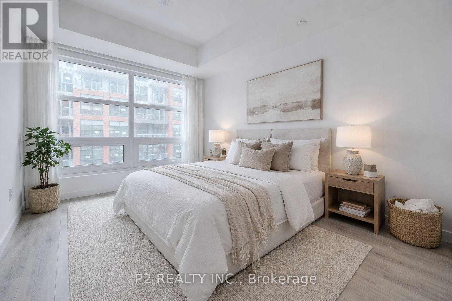 A well-lit bedroom with a large bed and a window overlooking a cityscape.