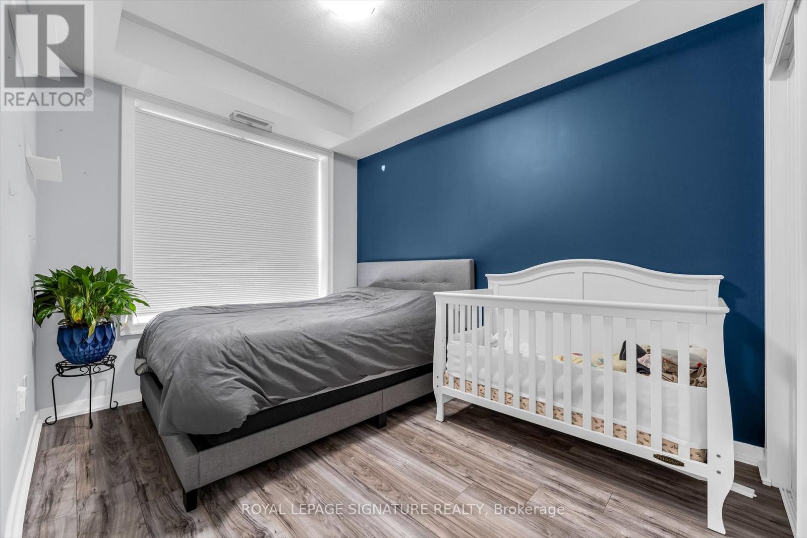 A bedroom with a white bed and a blue wall.