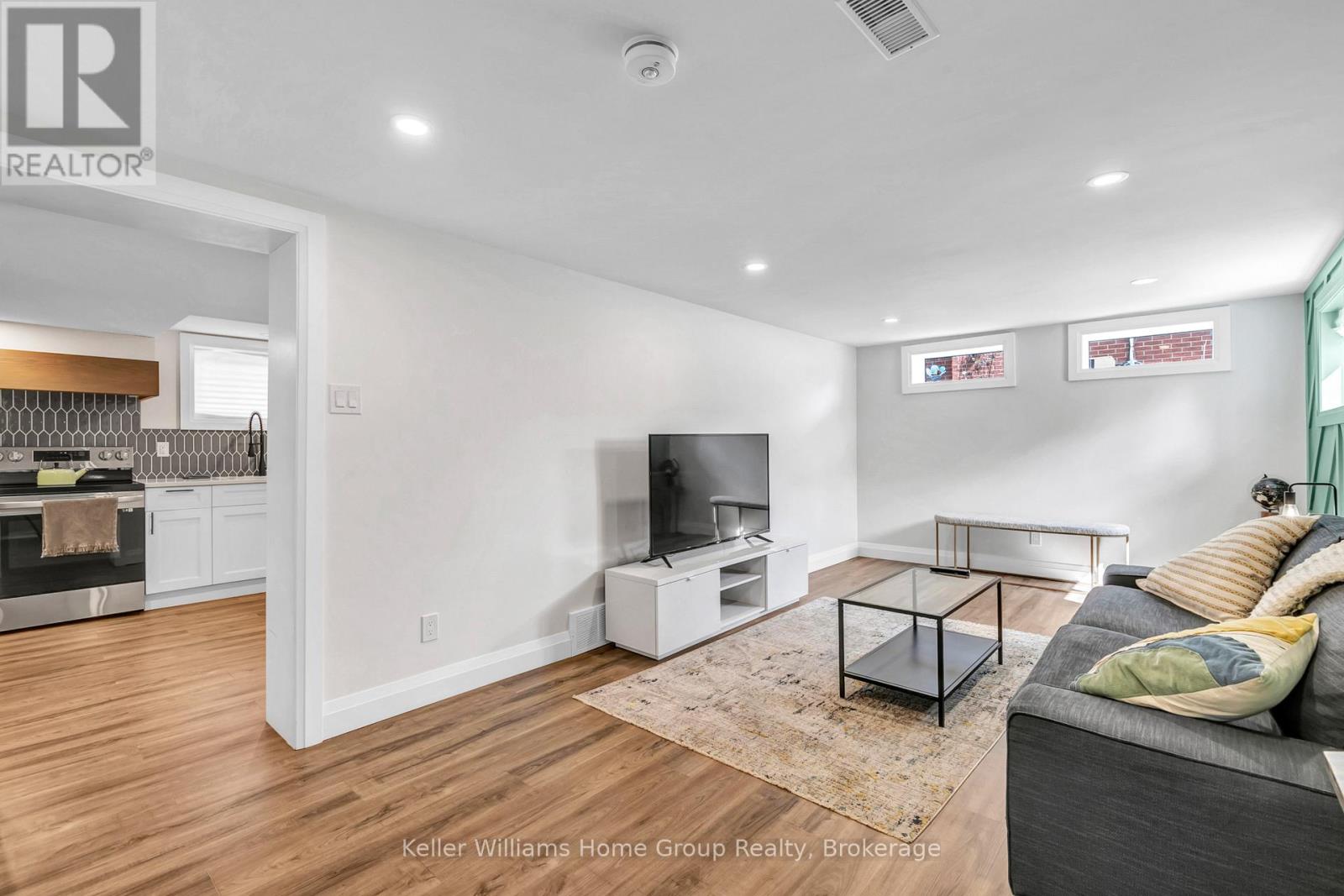 A living room with a grey couch and a wooden floor.