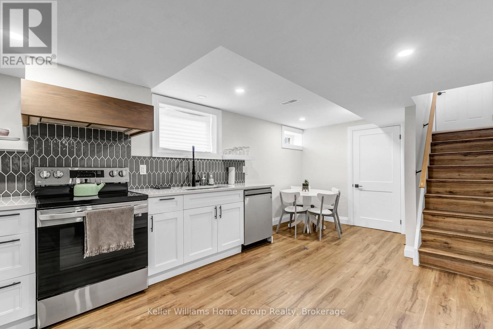 A modern kitchen with a wooden floor and white walls.