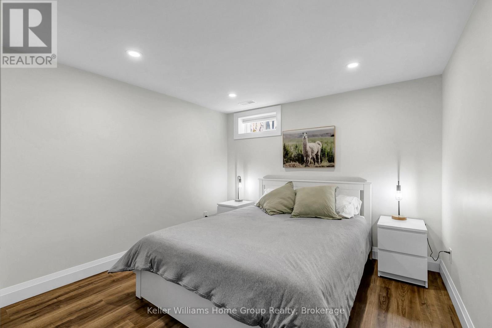 A bedroom with a bed, nightstand, and lamp.