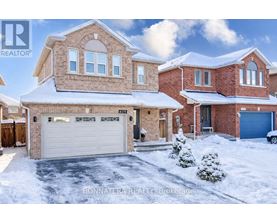 A house with a snow-covered front yard and a garage.