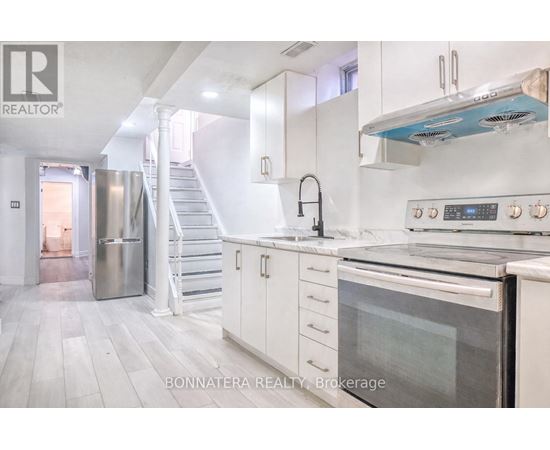 A modern kitchen with white cabinets and stainless steel appliances.