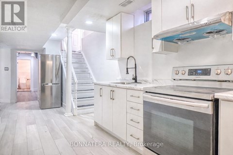 A modern kitchen with white cabinets and stainless steel appliances.