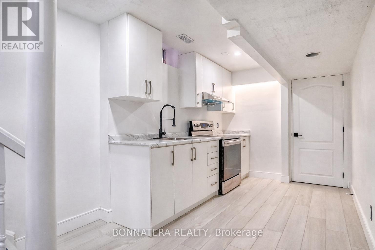 A white kitchen with a sink and cabinets.