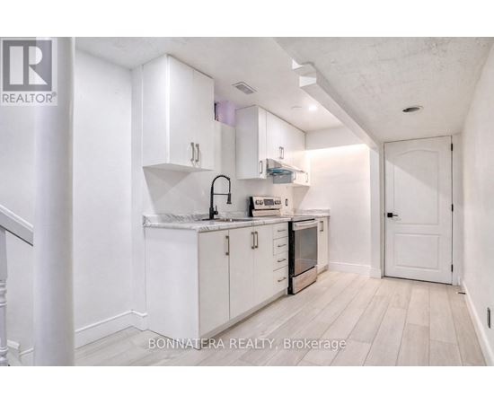 A white kitchen with a sink and cabinets.
