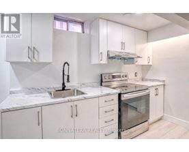 A kitchen with white cabinets and a marble countertop.