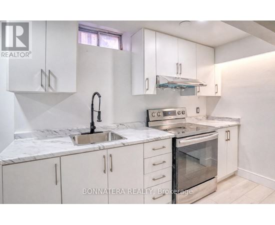 A kitchen with white cabinets and a marble countertop.