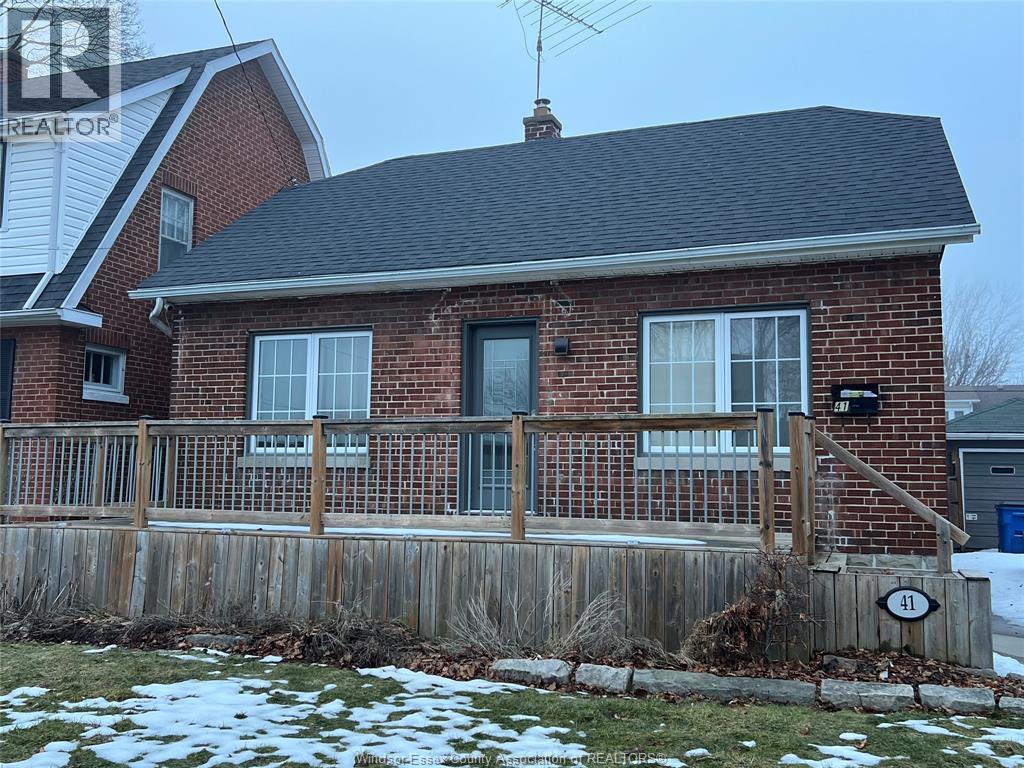 A house with a brick facade and a wooden fence.