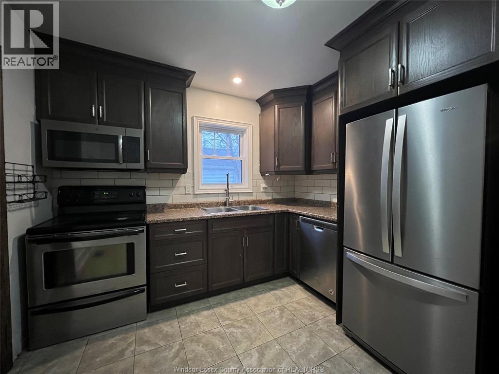 A kitchen with black cabinets and stainless steel appliances.