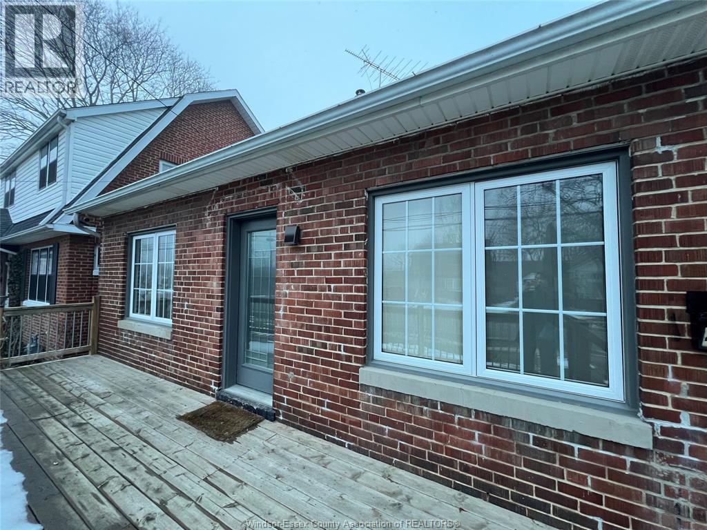 A red brick house with a grey door and a grey window.