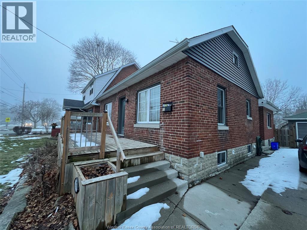 A brick house with a wooden deck in front.
