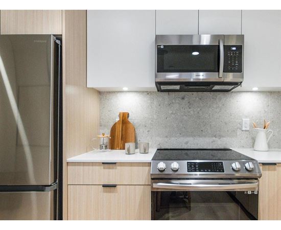 A modern kitchen with a stainless steel oven and microwave above it.
