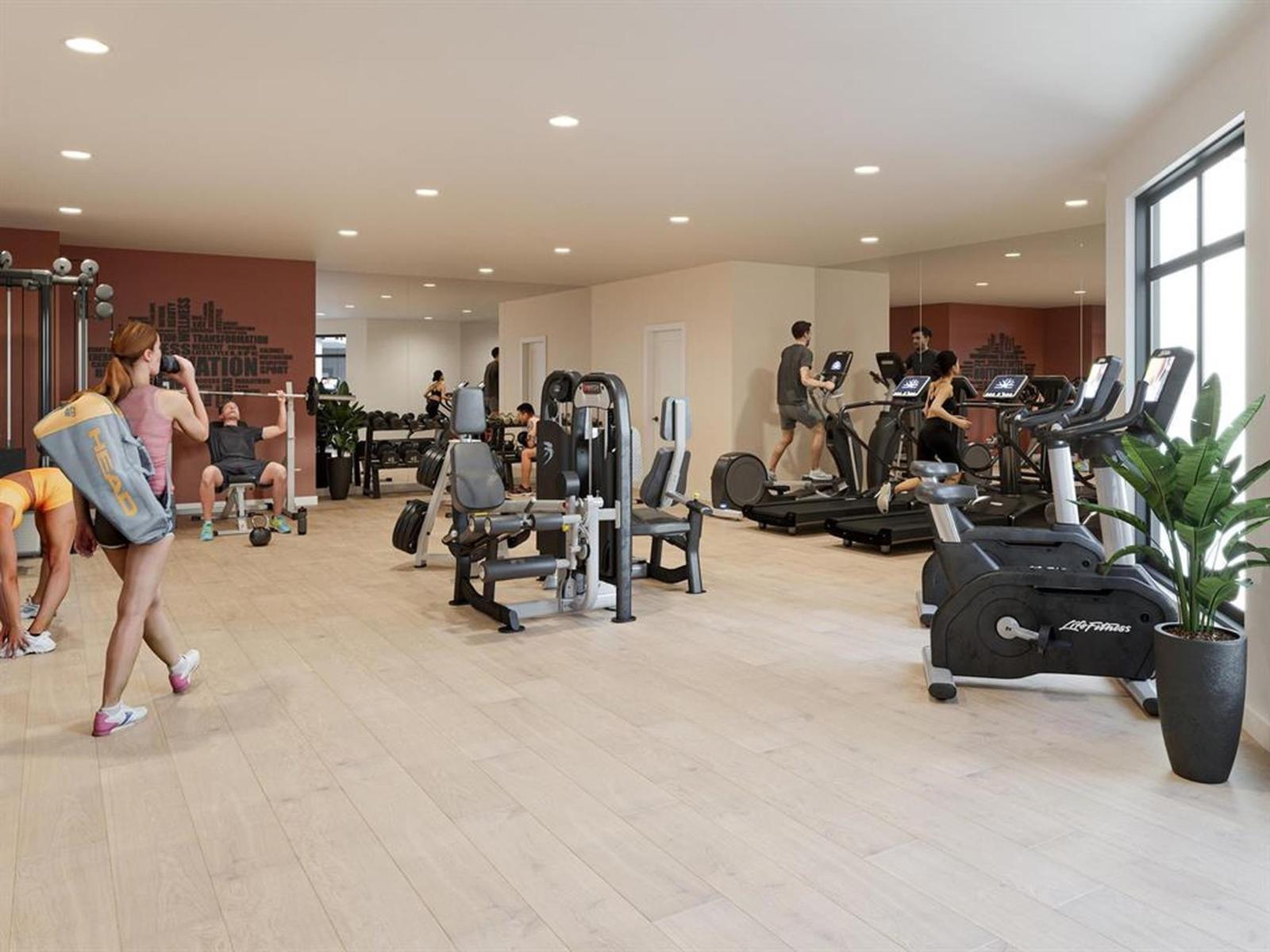 A woman is running on a treadmill in a gym with other people exercising.