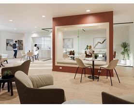A modern living room with a dining area in the background.
