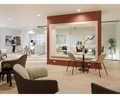A modern living room with a dining area in the background.