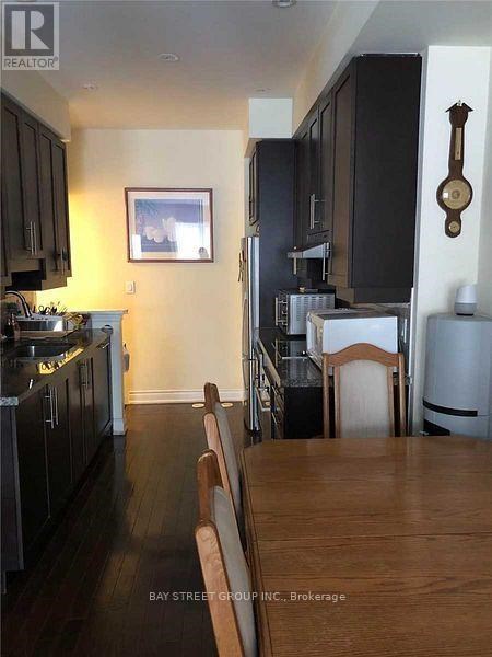 A kitchen with dark wood cabinets and a wooden table.