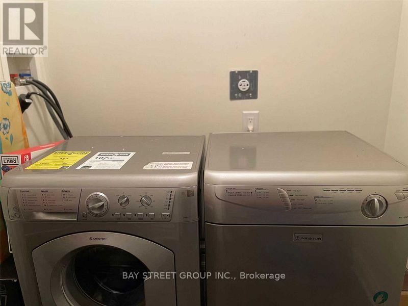 Two front load washing machines from Bay Street Group Inc. Brokerage are placed next to each other.