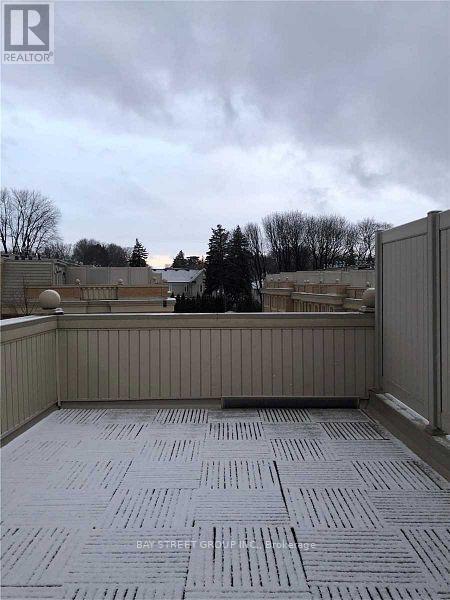 A rooftop with a grey tiled floor and a metal railing.