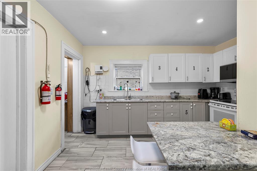 A kitchen with a granite countertop and cabinets numbered 1 to 5.