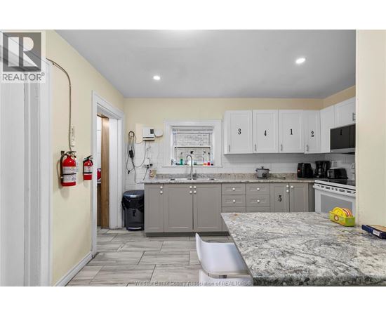 A kitchen with a granite countertop and cabinets numbered 1 to 5.