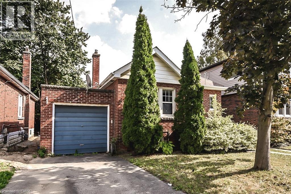 A house with a blue garage door and a tree in front.