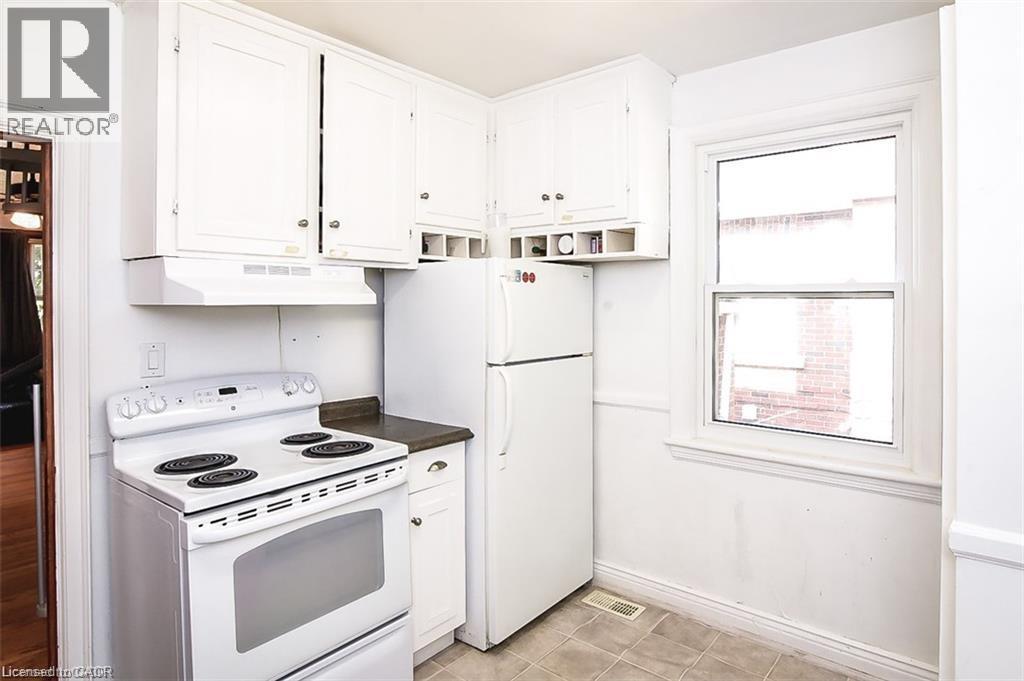 A white kitchen with a stove and refrigerator.