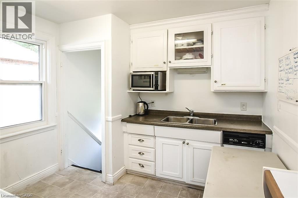 A white kitchen with a sink and a refrigerator.