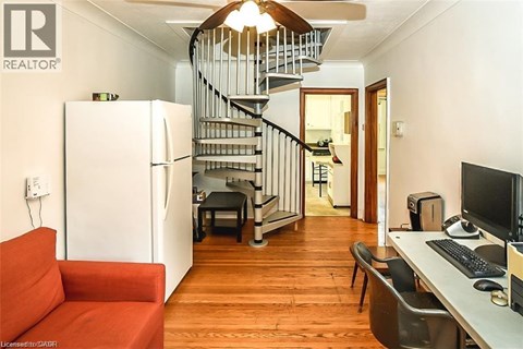 A living room with a red couch and a staircase.