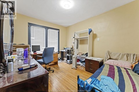 A bedroom with a bunk bed and a desk with a computer.