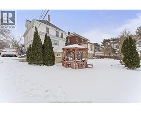 A house with a snow-covered front yard and a gazebo.
