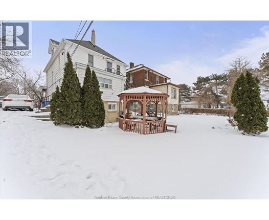 A house with a snow-covered front yard and a gazebo.