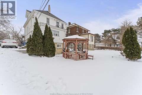 A house with a snow-covered front yard and a gazebo.