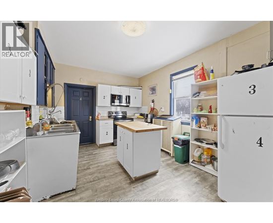 A kitchen with white cabinets and a blue door.