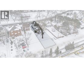 A snowy landscape with a house and trees.