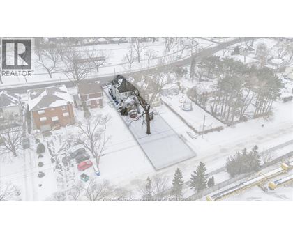 A snowy landscape with a house and trees.