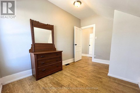 A bedroom with a wooden dresser and mirror.