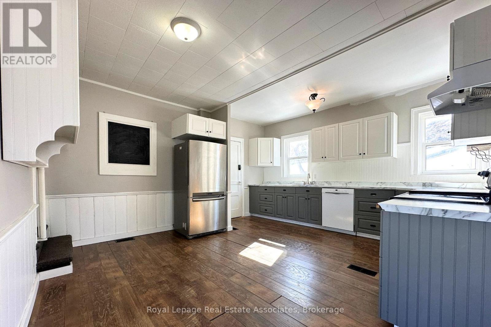 A kitchen with wooden floors and white walls.