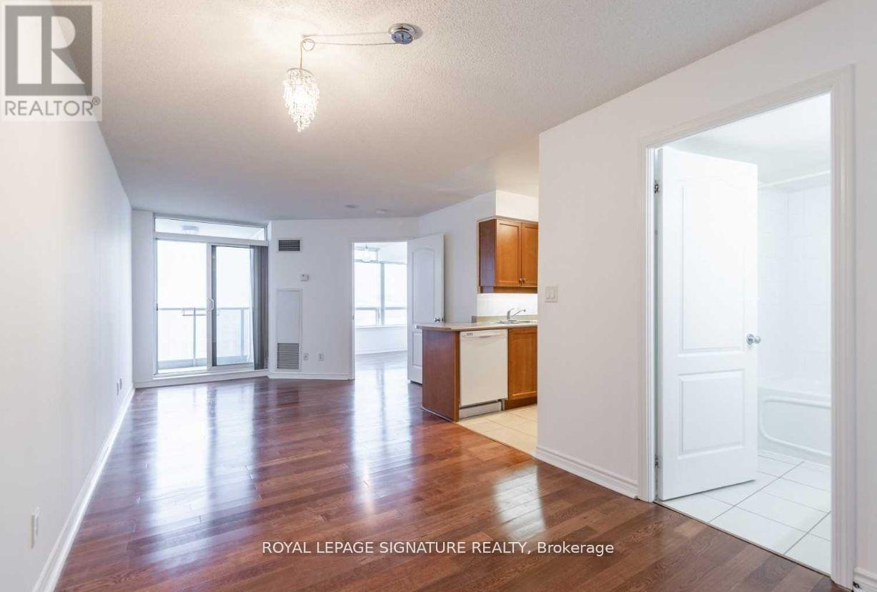 A spacious room with wooden floors and white walls.