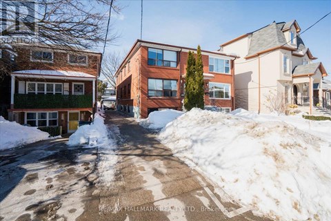 A snow-covered street with houses on either side.
