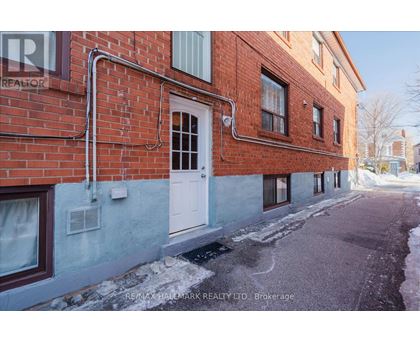 A red brick building with a white door and windows.