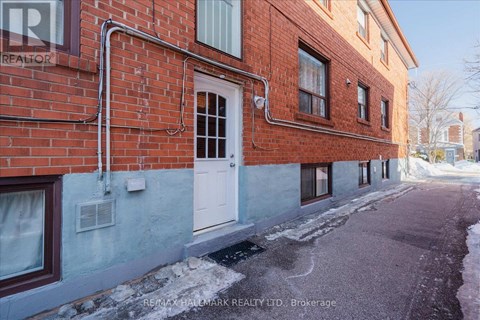 A red brick building with a white door and windows.