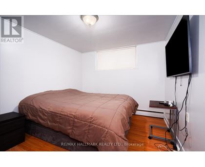 A bedroom with a bed, a television, and a window.