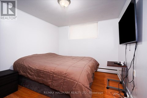 A bedroom with a bed, a television, and a window.