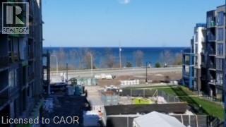 A view from a high-rise building looking out over a parking lot and a body of water.