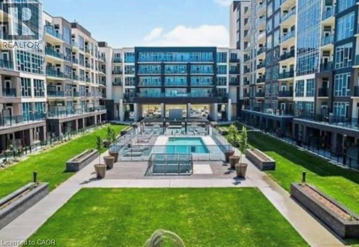 A large, modern building with a pool in the middle of a grassy area.